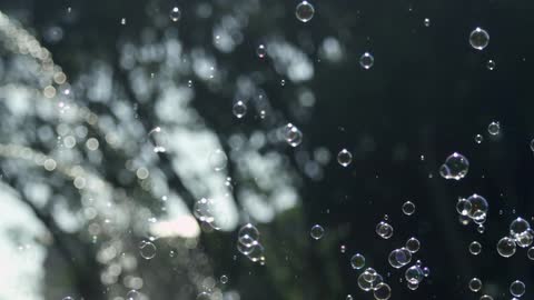 Water is spraying from a fountain and causing bubbles