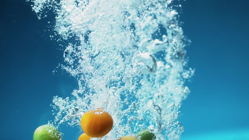 Oranges lemons and limes float to the bottom of the water as bubbles rise
