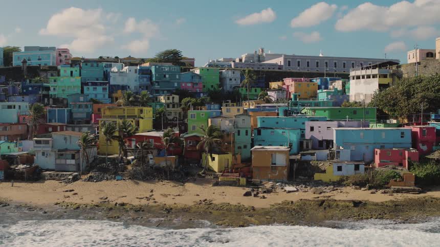 Colorful building crowd the beach as waves roll in