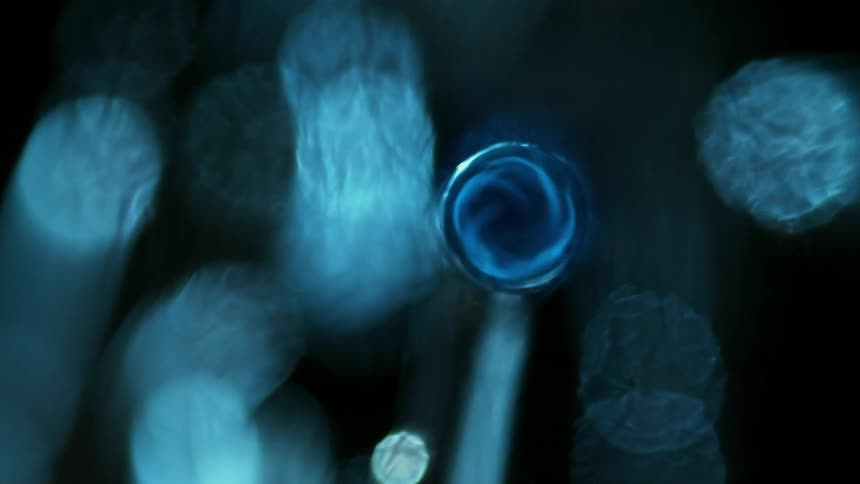 Sparks and flames and light shimmer as a liquid surface ripples