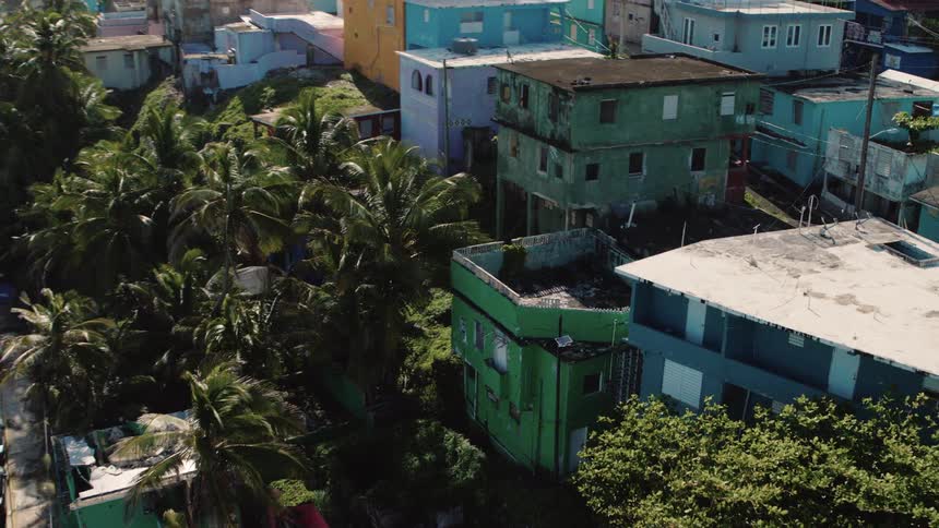 Colorful buildings in various states of repair border the beach