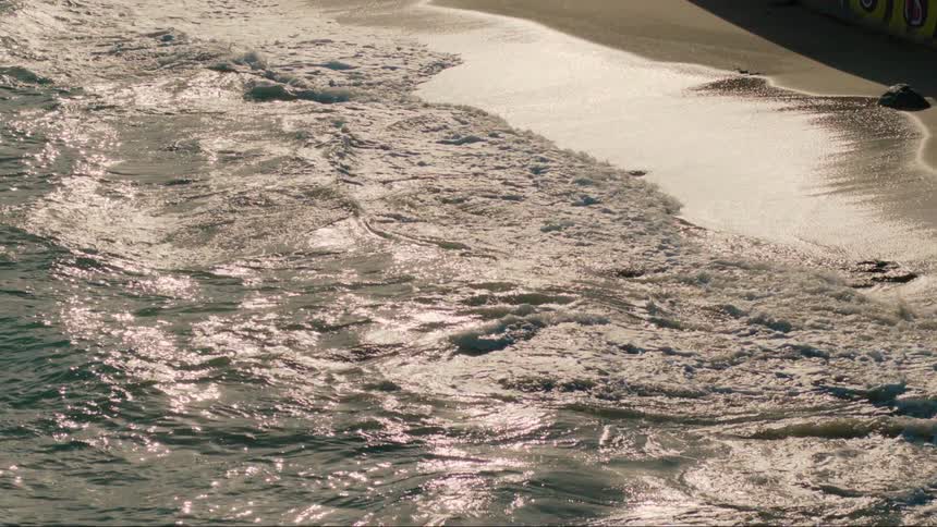 The tide rolling into a sandy beach
