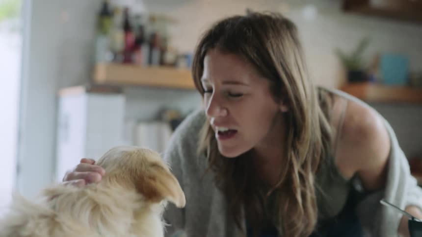 A woman tries to kiss her dog
