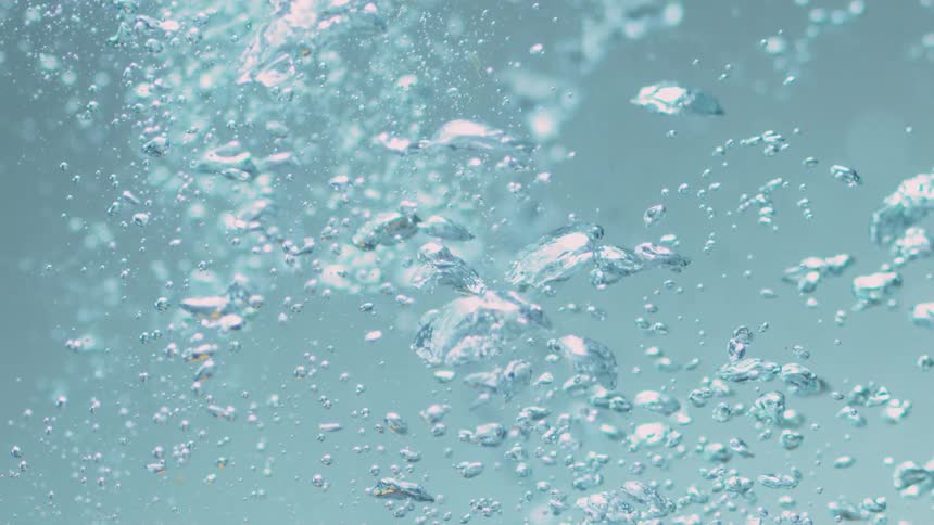 Within crystal clear water numerous bubbles slow begin to rise upwards