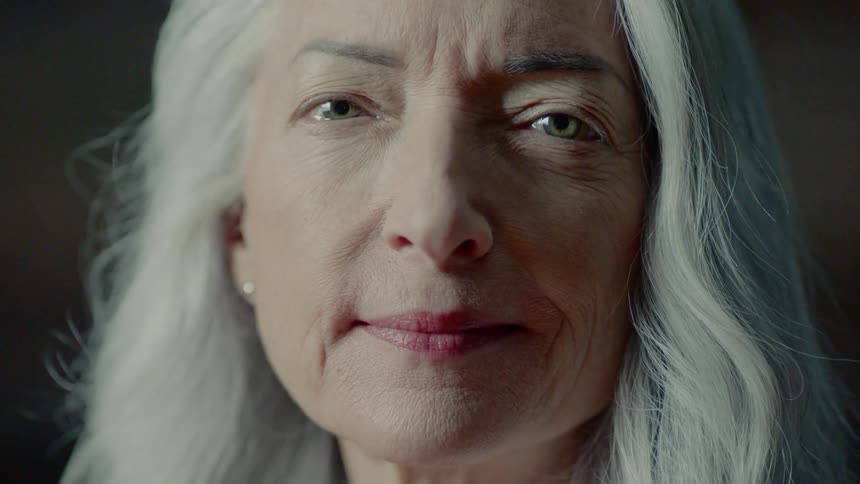 A light passes over an attractive gray haired woman