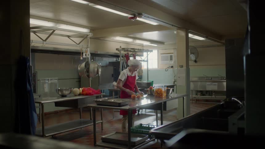 Woman slices oranges with a knife in a kitchen