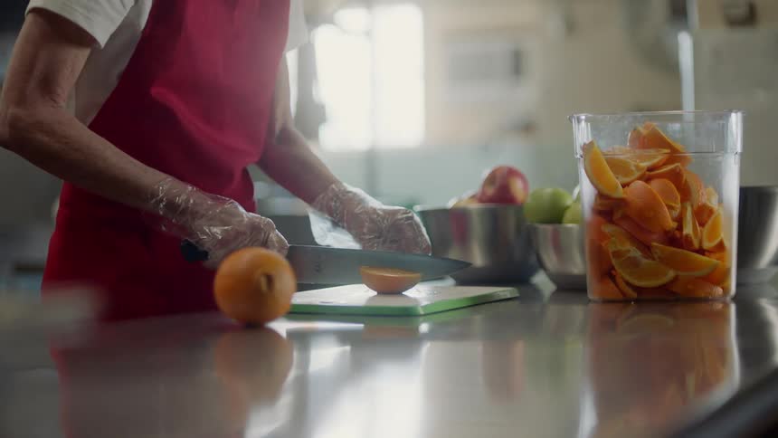 Person slices oranges in the kitchen