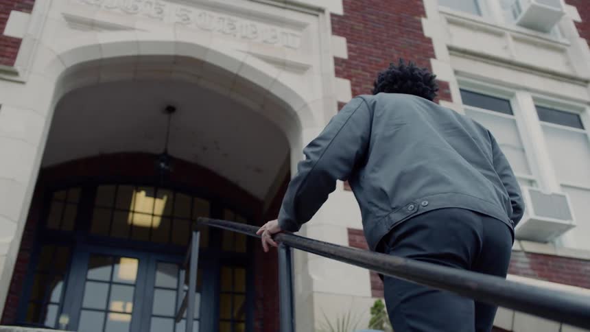 Man walks up stairs to the entrance of a building