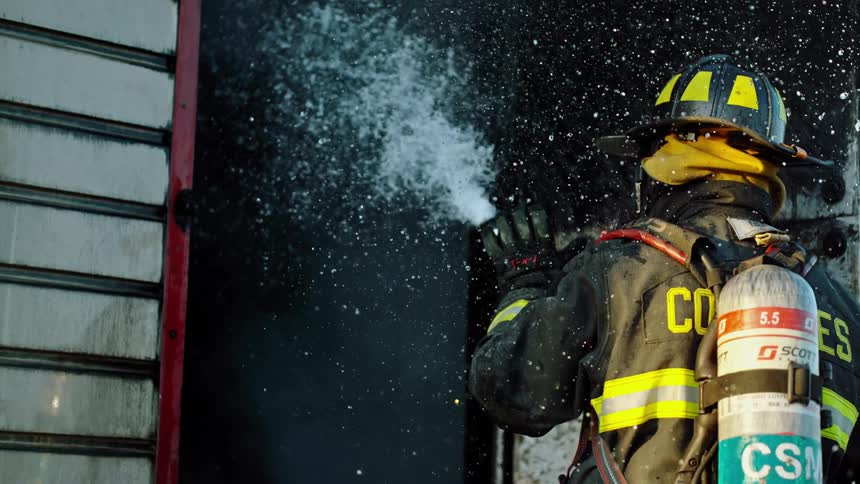 A firefighter with a hose spraying water