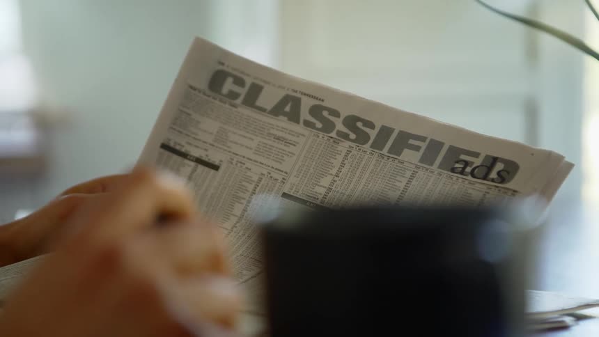 A cup of coffee near newspaper