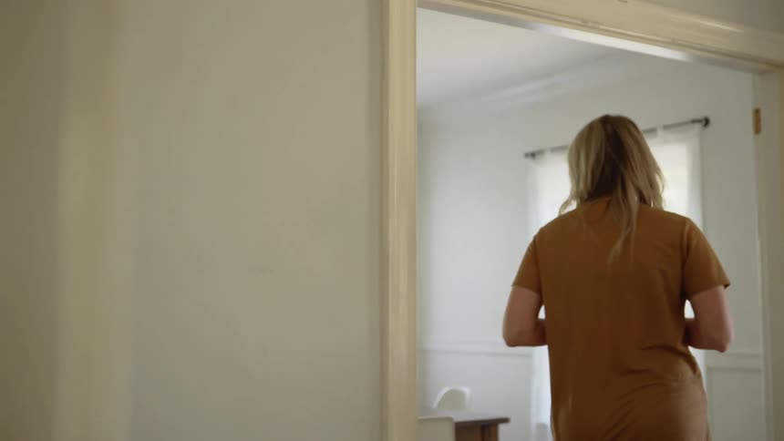Woman leans against wall taking a breather then returns to sit at table