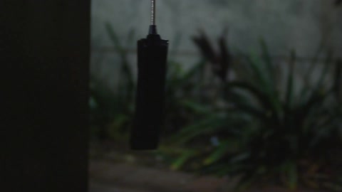 A phone connected to a phone booth dangles off the hook