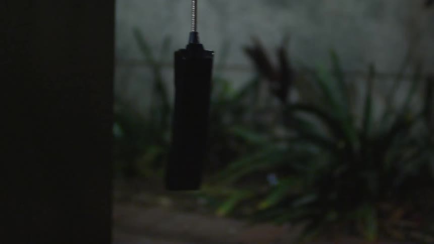 A phone connected to a phone booth dangles off the hook