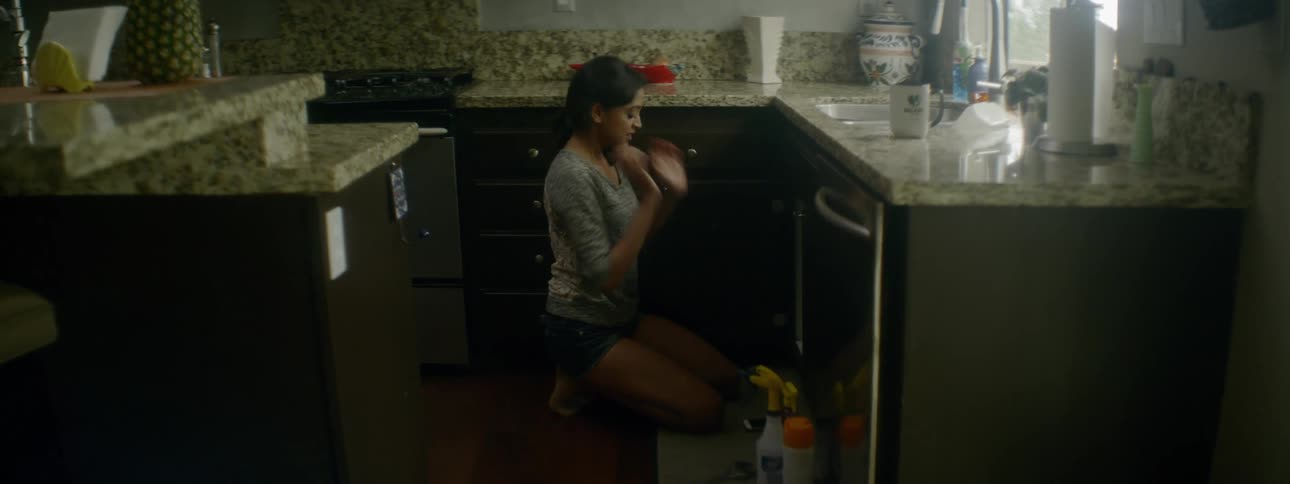 A woman crawling around in a cabinet