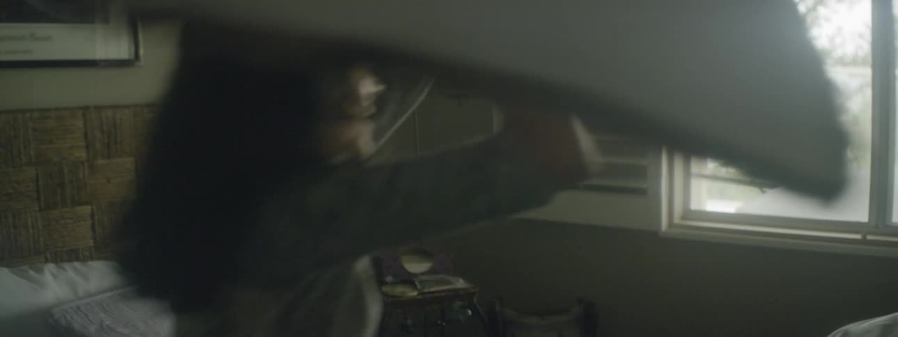 Man and woman do pillow fight on the bed in the bedroom