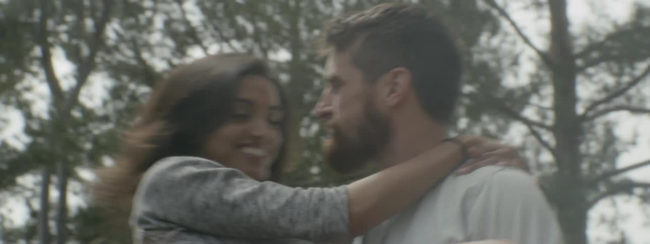 A man lifting and carrying a woman while he spins around