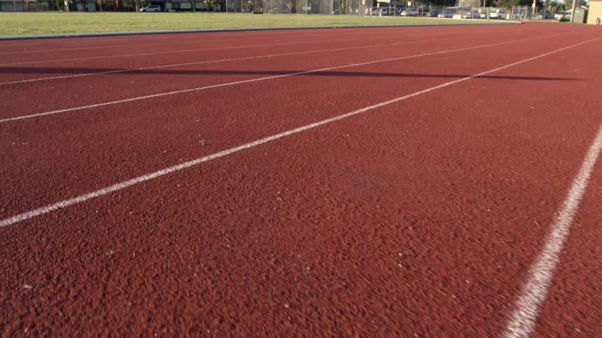A shadow can be seen on a running track on a sunny day