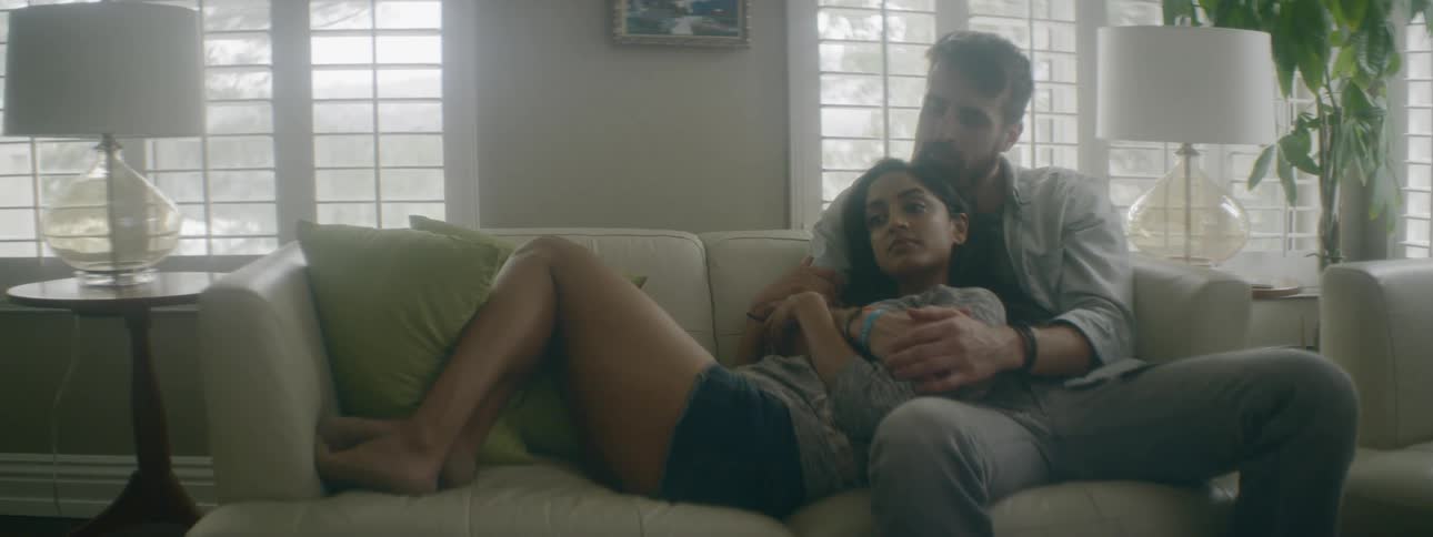 Couple sitting in couch at house relax in each other arms