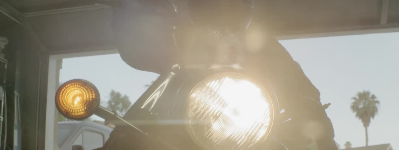 A man parks his motorcycle in the garage