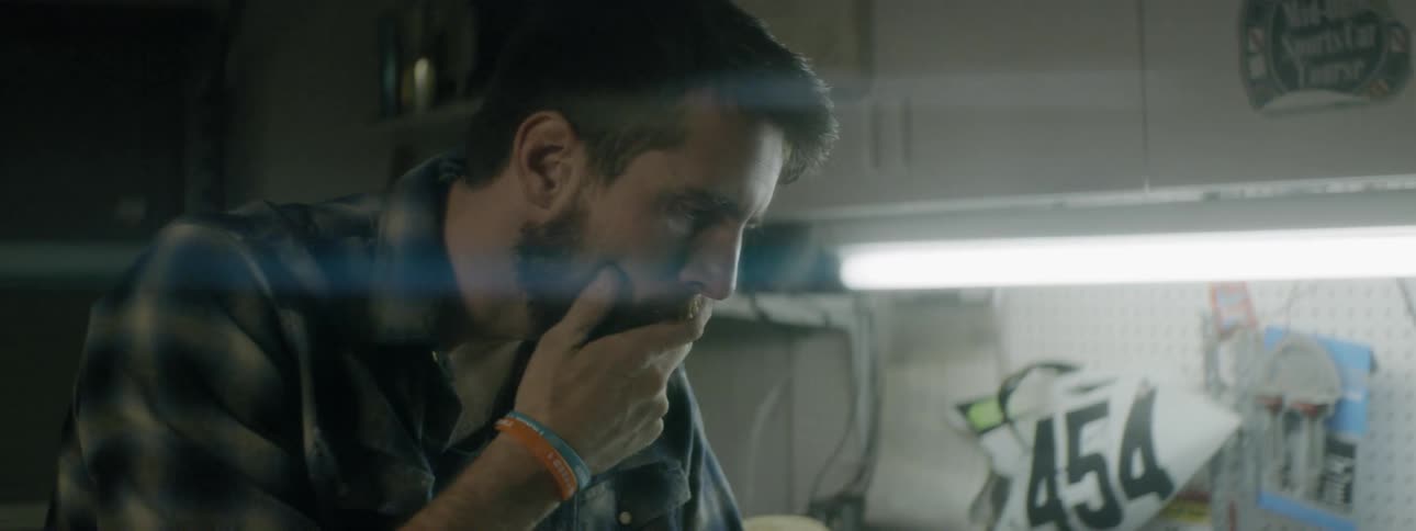 Man tosses a cloth on the work table then scratches his beard