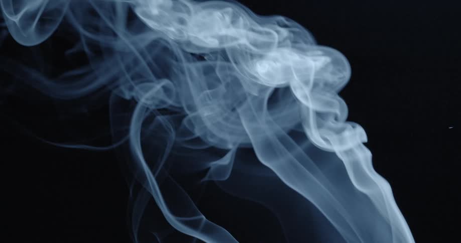 Ribbons of blue and white smoke curl and rise against black