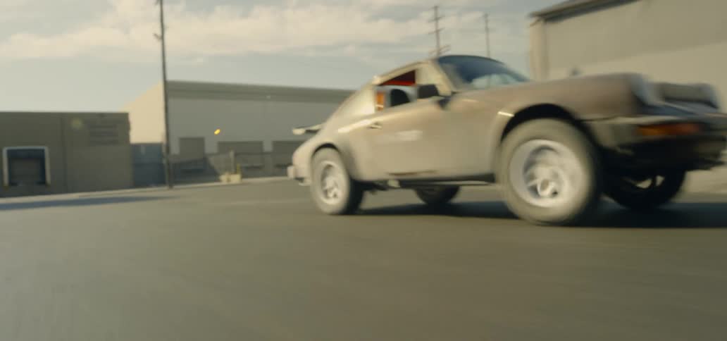 Sports car races along city streets near small buildings