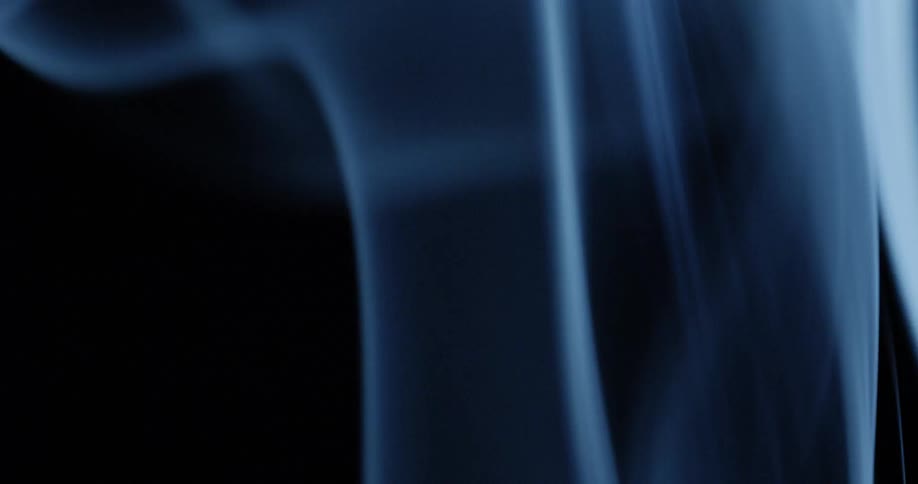 Blue smoke being blown over black background