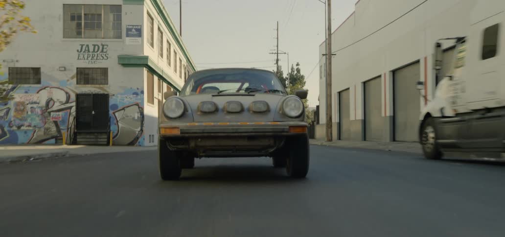 Sports car driving on small town street at day