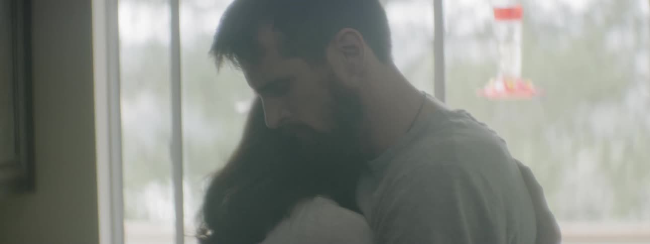 A man and woman embracing in a house