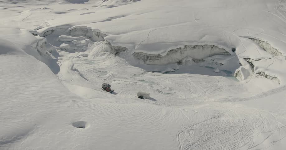 A bird flies over the snow filled hills