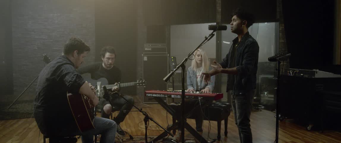 Four members of a band perform in a studio