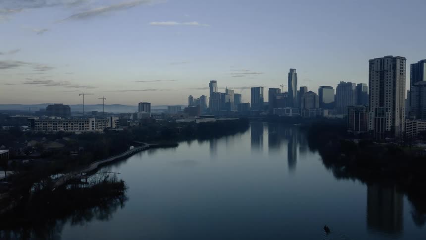 Time lapse view of a boat in a lake with the city in the background