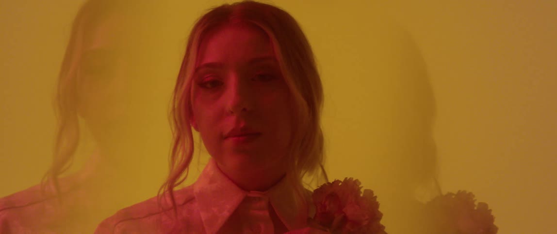 A woman holds a flower