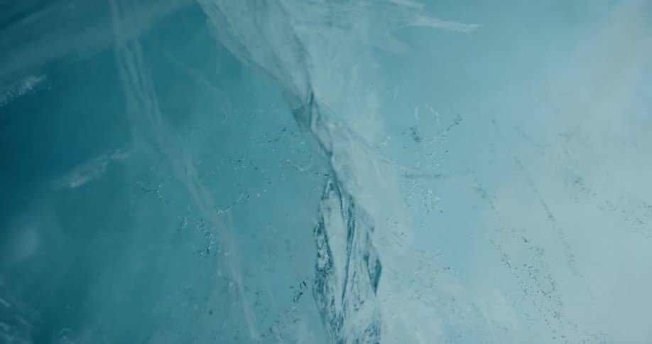 A fissure and many small cracks can be see within a frozen piece of ice