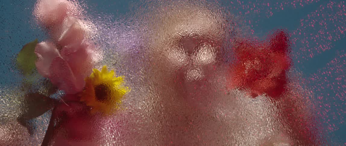 Woman looks through frosted glass