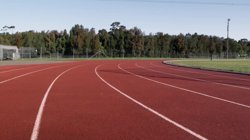 A track is red with white lines on a cloudy day