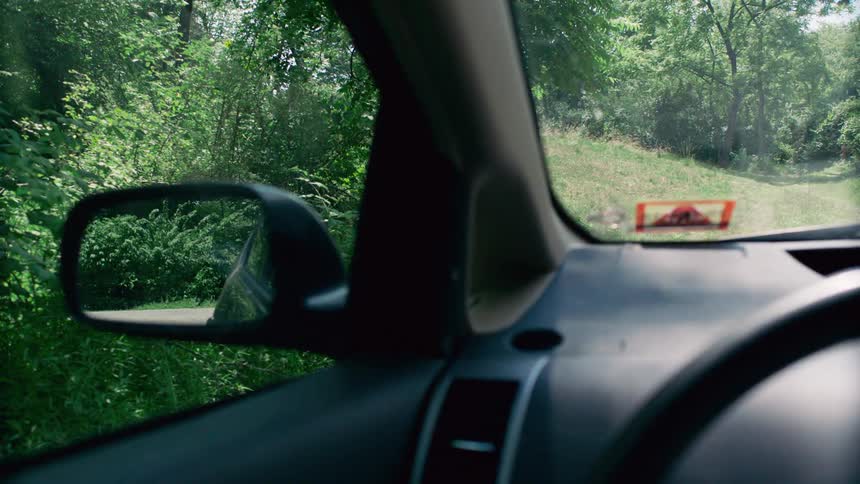 A car driving by in the side mirror of another car
