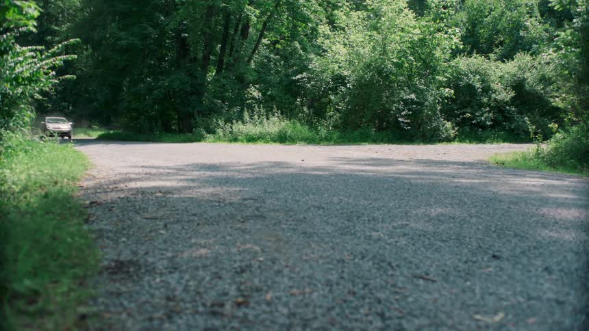 A vehicle speeds down a rural road