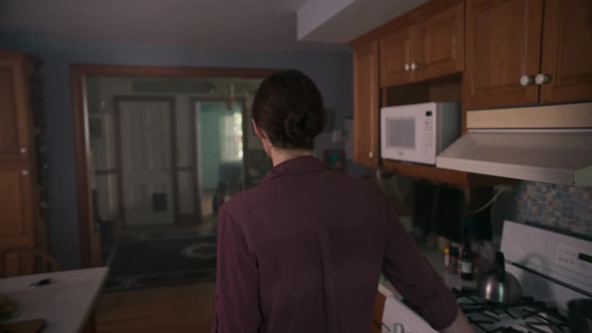 A woman walks in her kitchen