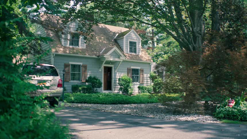 A woman leaves out the front door of her house