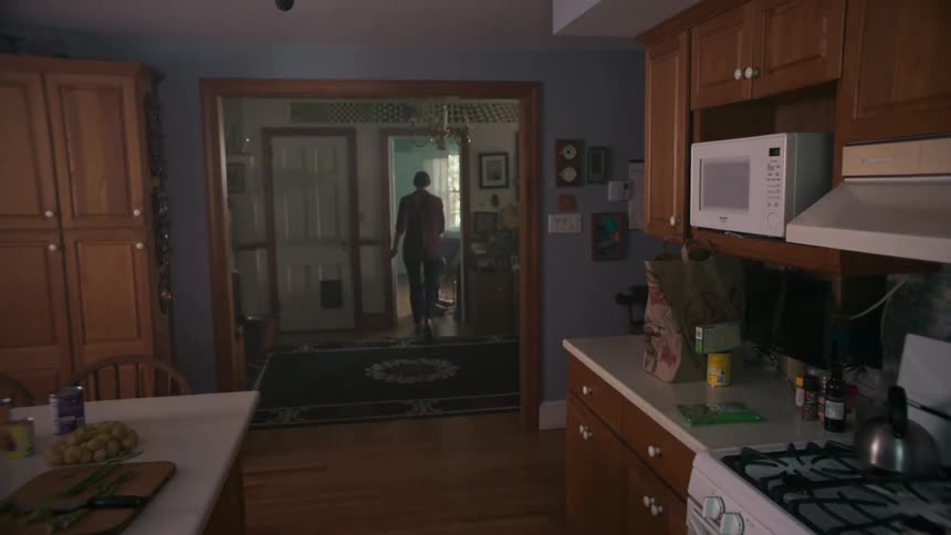 A woman walks out of the kitchen