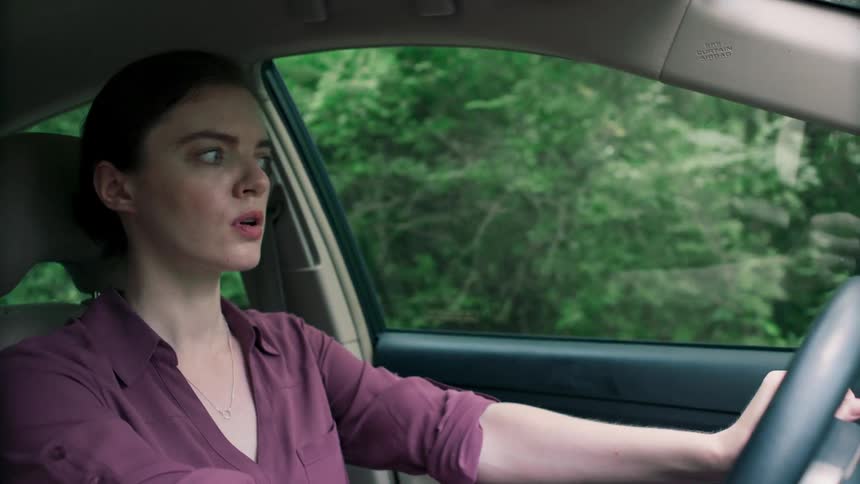 Woman driving road stopped abruptly looking shocked