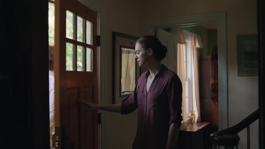 A woman says goodbye to her husband as he leaves their house