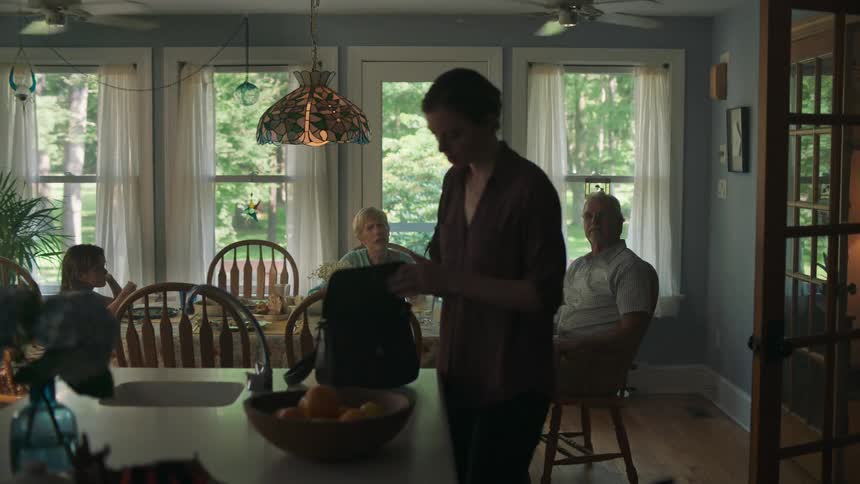A woman entering a dining room to search her purse for something