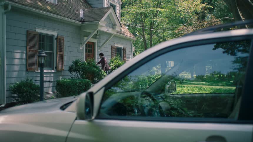 A woman closing the door behind herself as she leaves a house