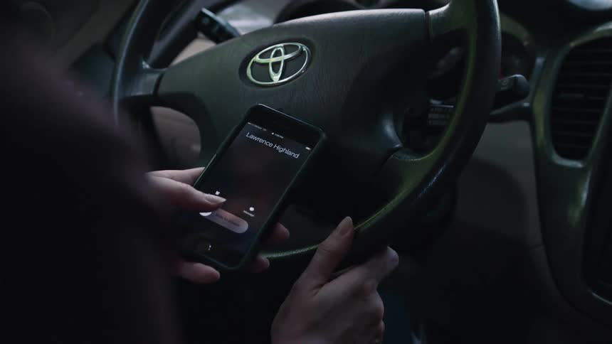 A person using their smartphone while sitting in a vehicle