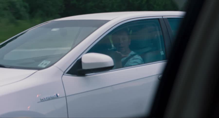 A man driving a car signals to another driver