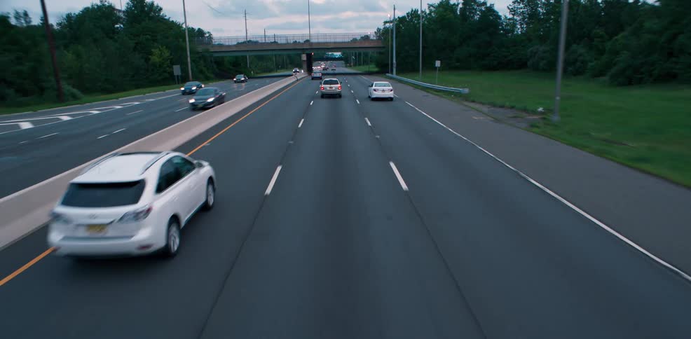 Vehicles drive down the freeway in the late afternoon