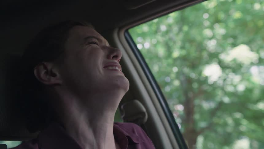 Woman gets into car and sits in seat sobbing