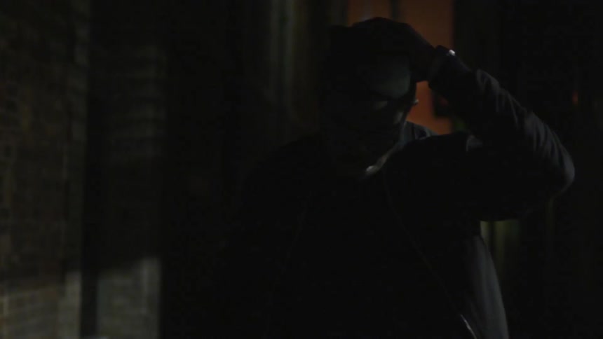 A man walks down an alley alone at night